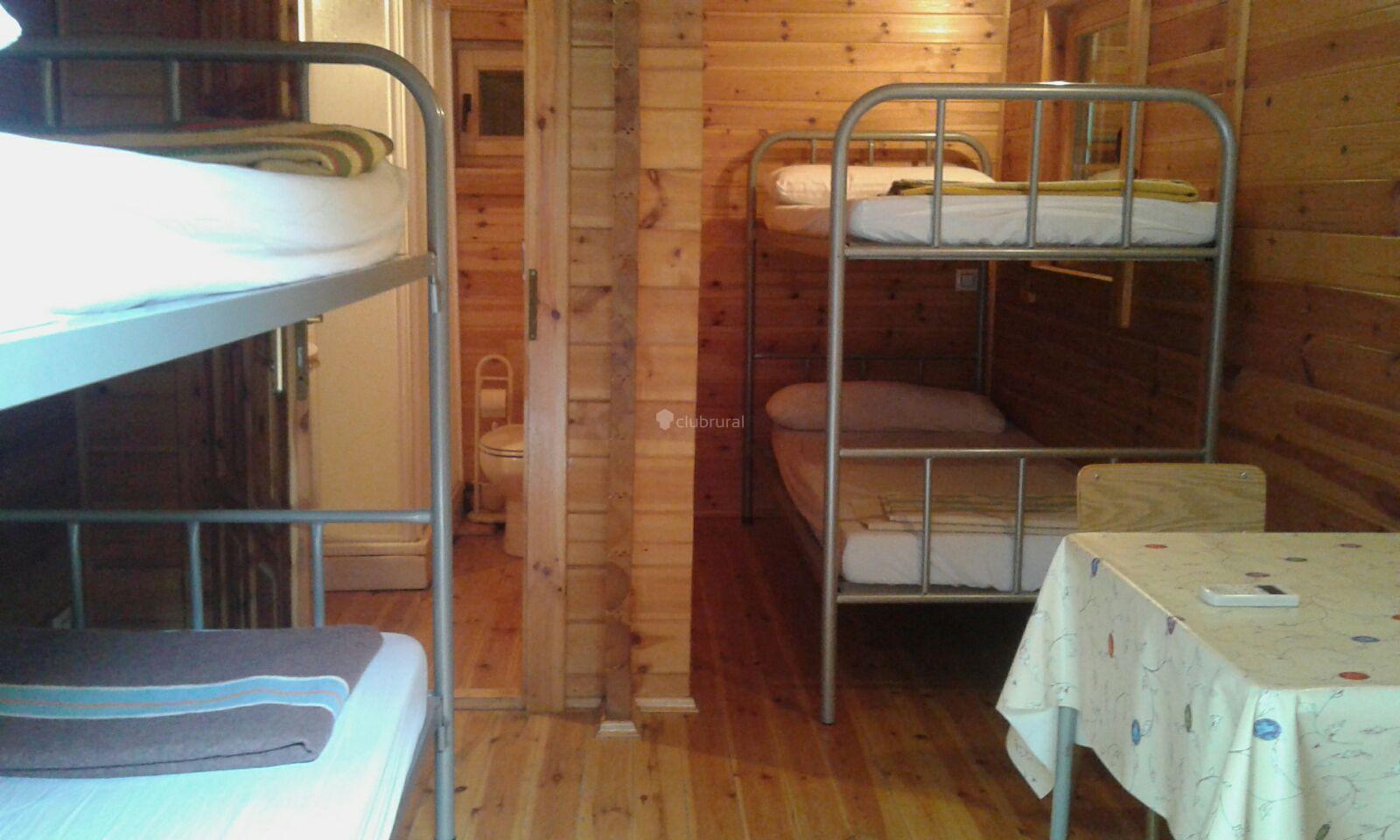 Interior de una cabaña de madera con literas