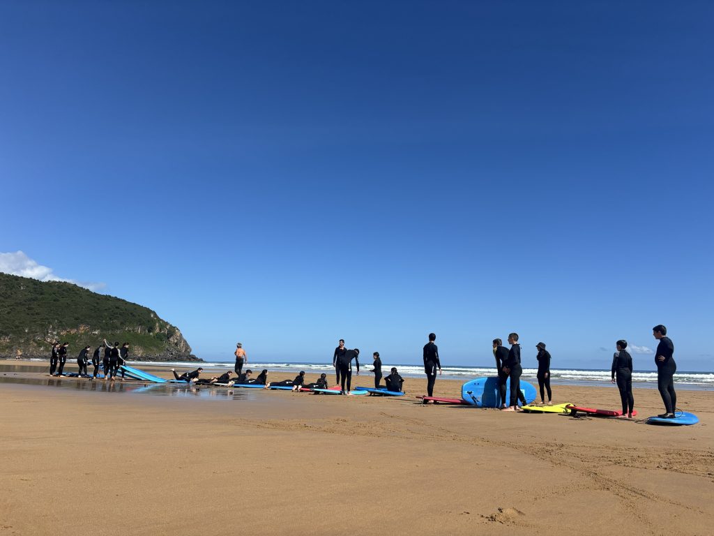 Estudiantes con tablas de surf en la orilla de la playa de Berria