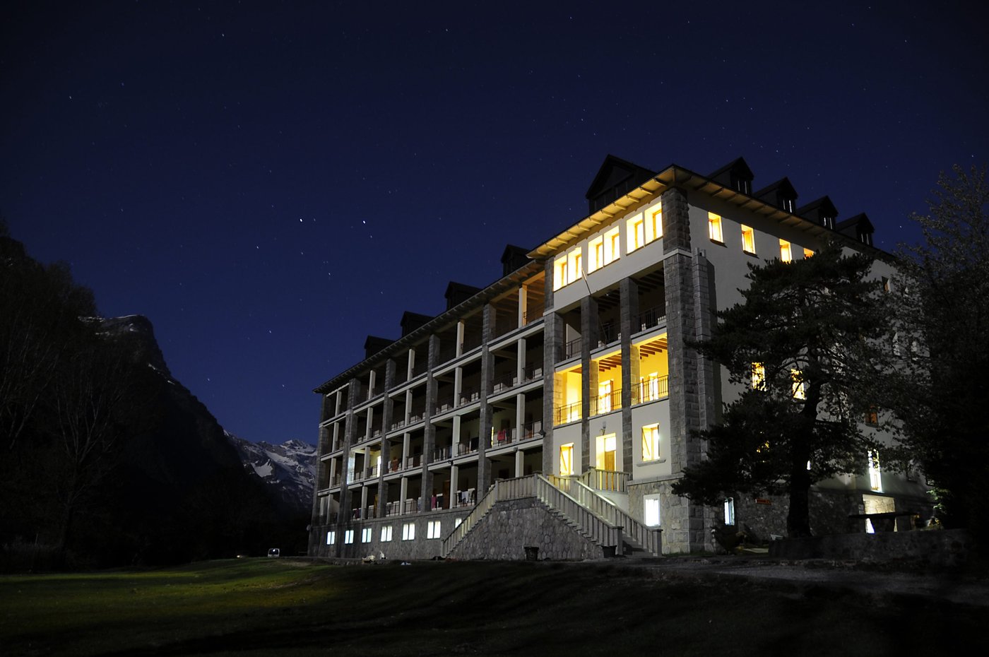 El albergue iluminado de noche bajo un cielo estrellado