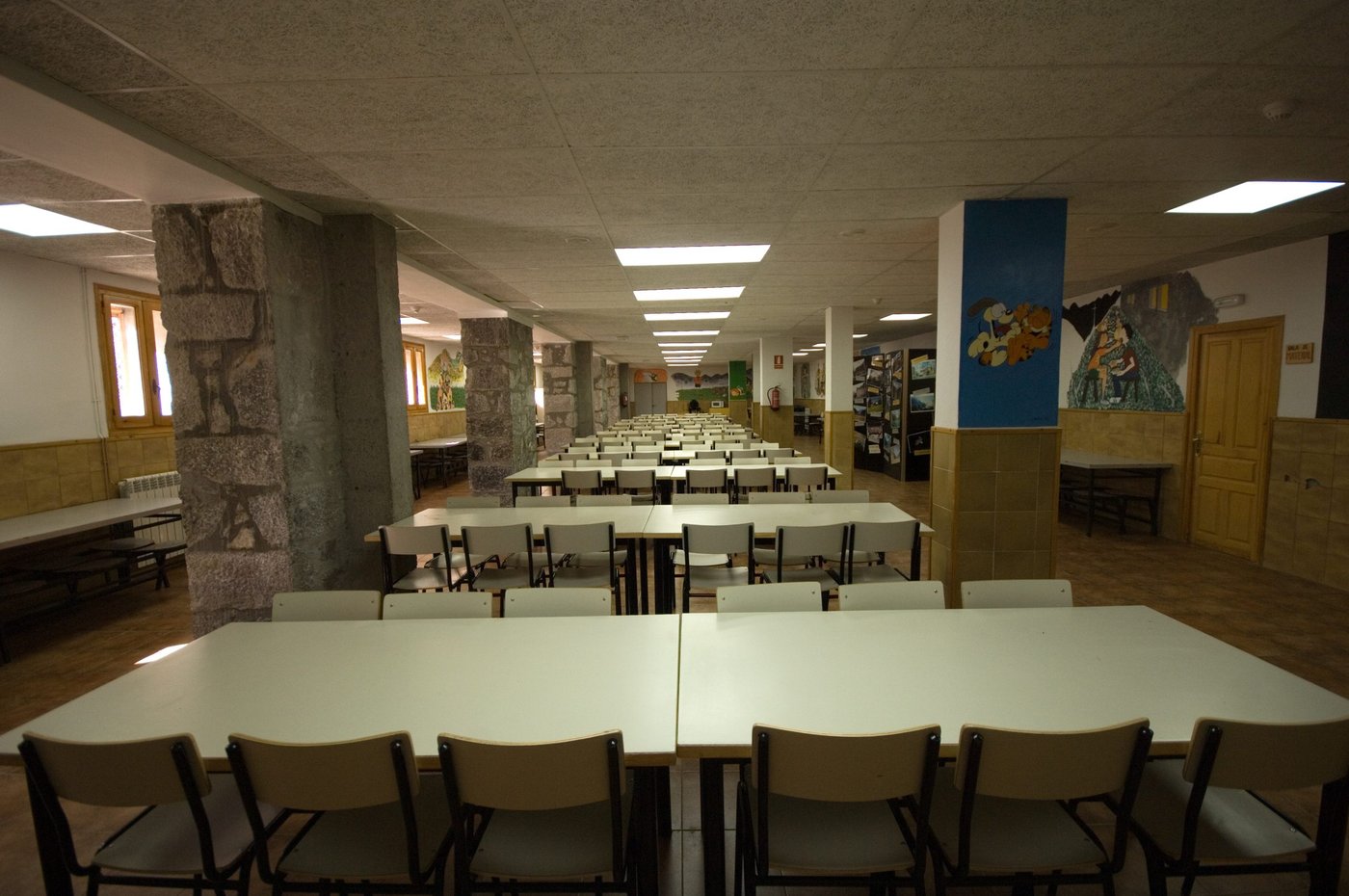 Comedor del albergue con mesas corridas