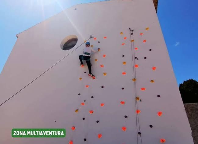 Estudiante escalando el rocódromo de la instalación