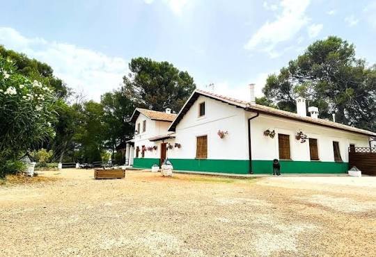 La casa forestal de Morciguillinas con su fachada blanca y verde