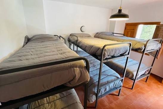 Habitación con varias literas y suelo de barro