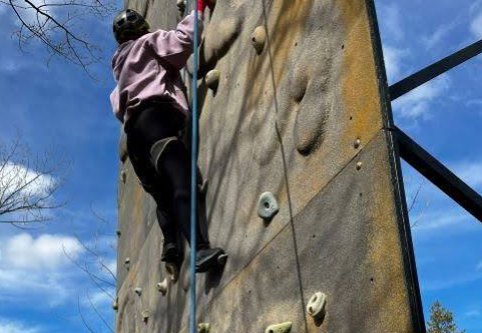 Estudiante escalando el rocódromo de la instalación