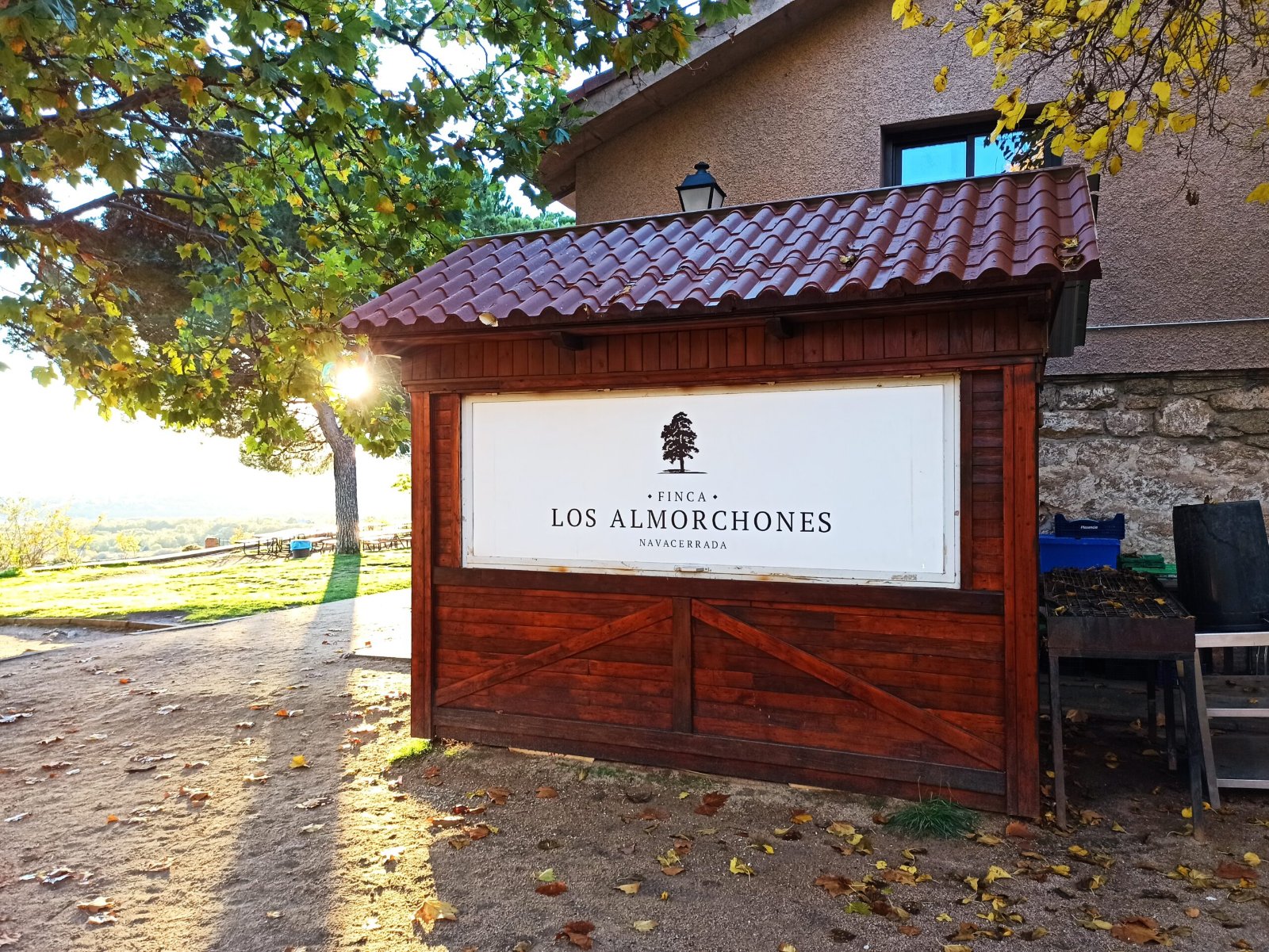 Caseta de madera con el cartel de la finca junto al albergue